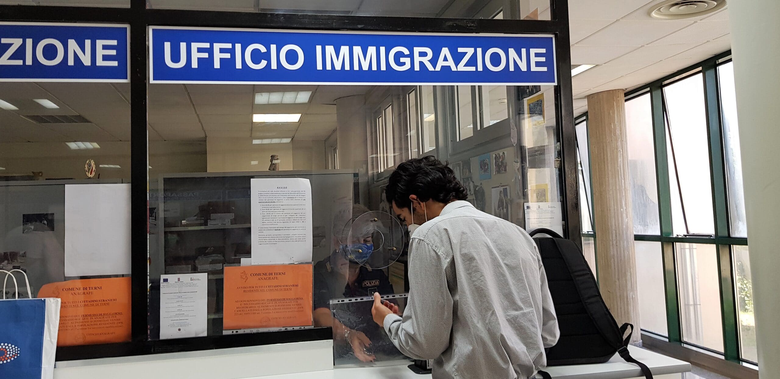 Immigrato o straniero alla questura presso ufficio immigrazione per impronti digitali per il permesso di soggiorno